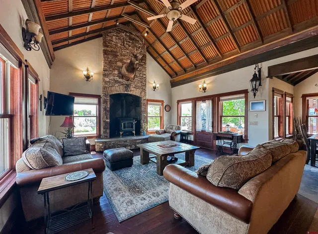 a living room with furniture a fireplace and a large window