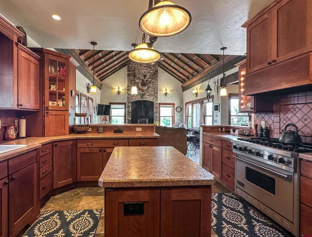 a kitchen with stainless steel appliances granite countertop a stove a sink dishwasher and cabinets with wooden floor