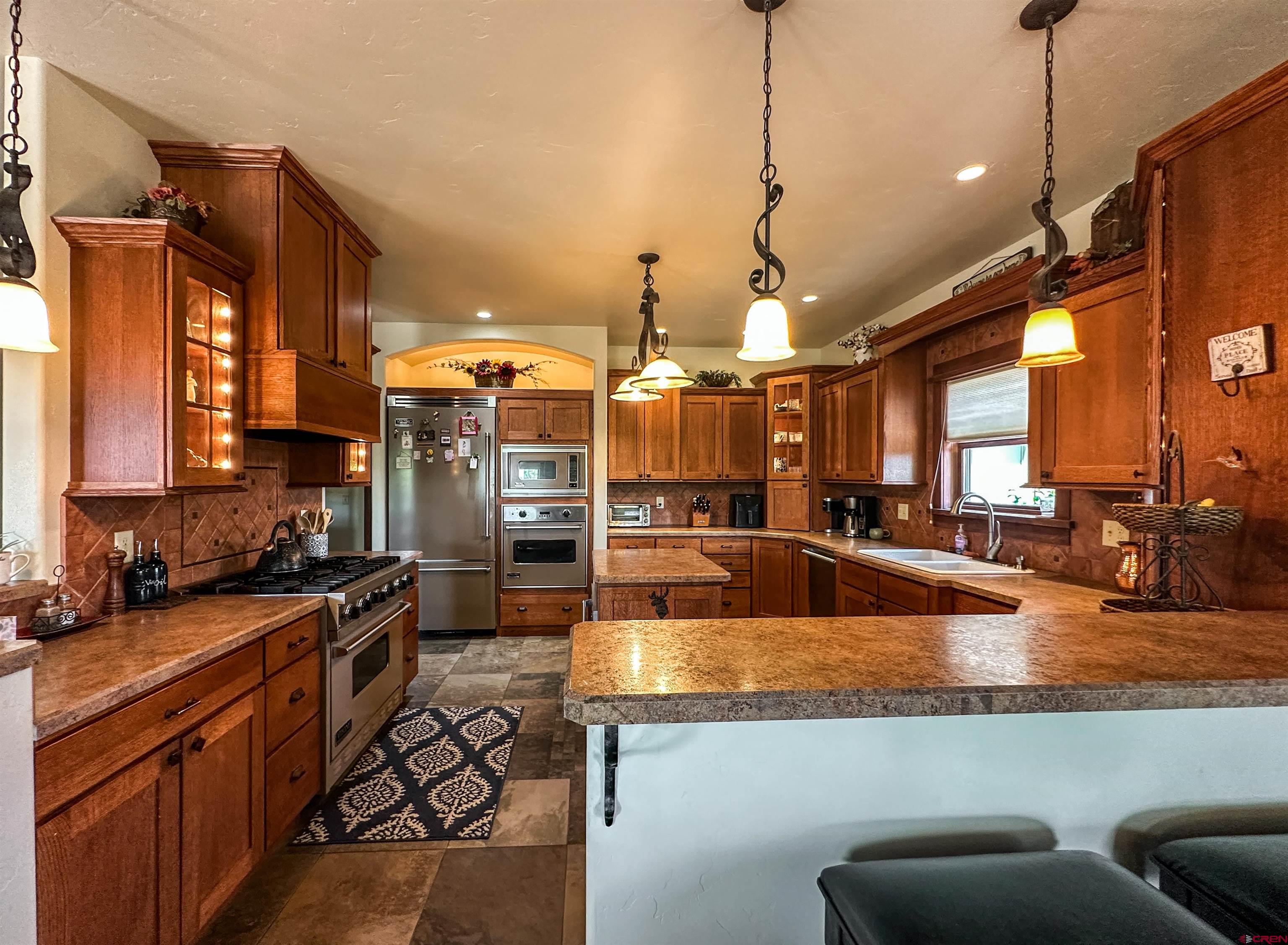 7276 5550th Road Olathe, CO 81425 - Photo 15 of 45 a kitchen with stainless steel appliances granite countertop a sink a stove and a wooden floors