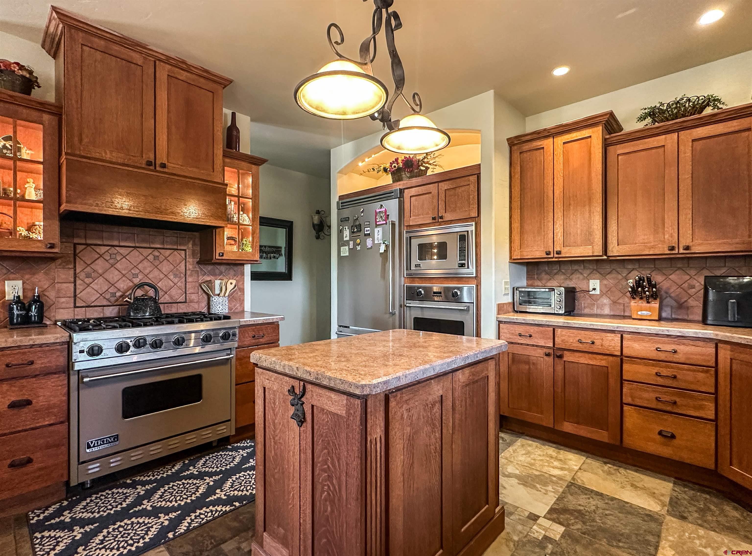 7276 5550th Road Olathe, CO 81425 - Photo 16 of 45 a kitchen with stainless steel appliances granite countertop a stove a sink and a refrigerator