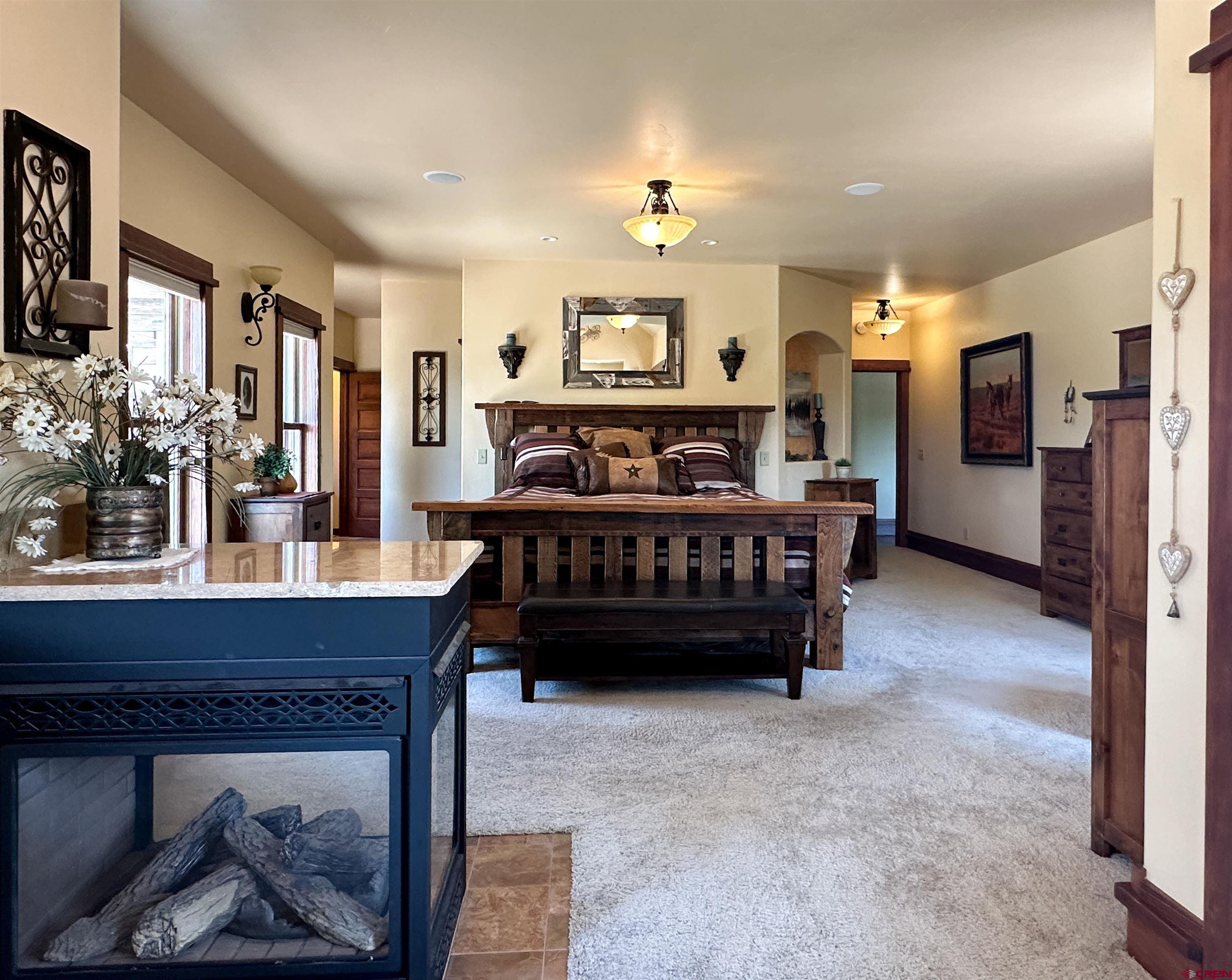 7276 5550th Road Olathe, CO 81425 - Photo 18 of 45 a bed room with furniture and a chandelier