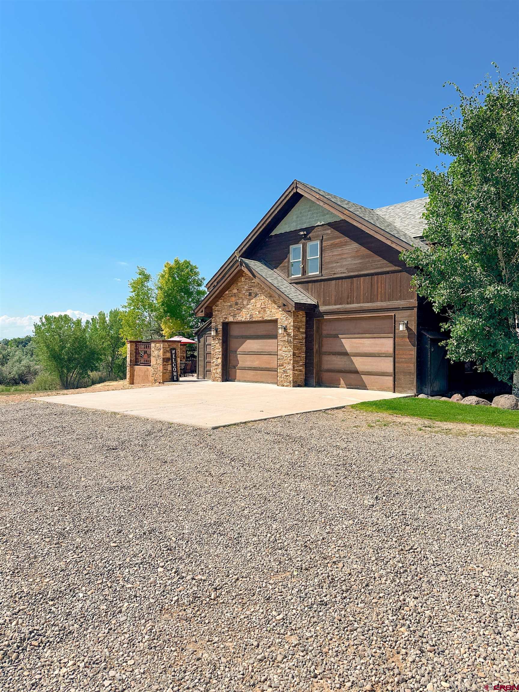 7276 5550th Road Olathe, CO 81425 - Photo 33 of 45 a front view of a house with a yard and garage