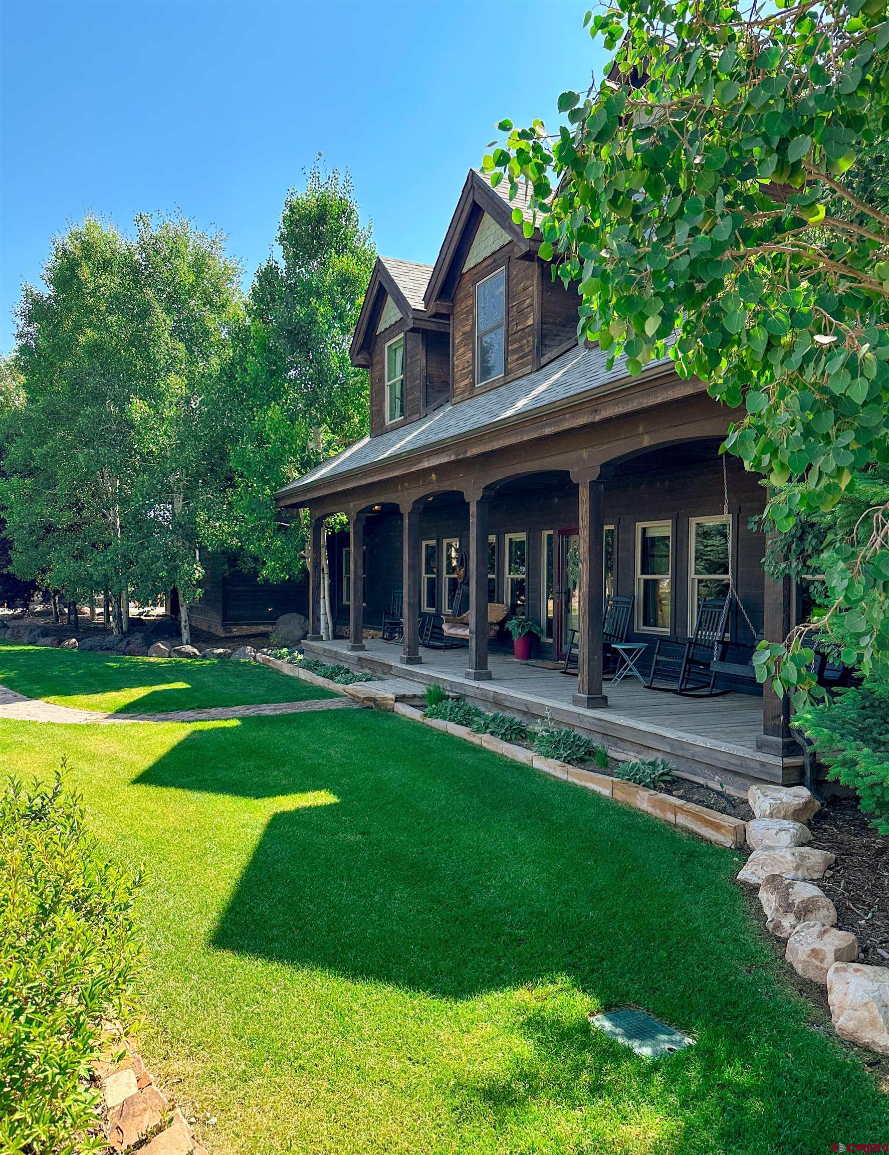 7276 5550th Road Olathe, CO 81425 - Photo 4 of 45 a front view of a house with a yard table and chairs