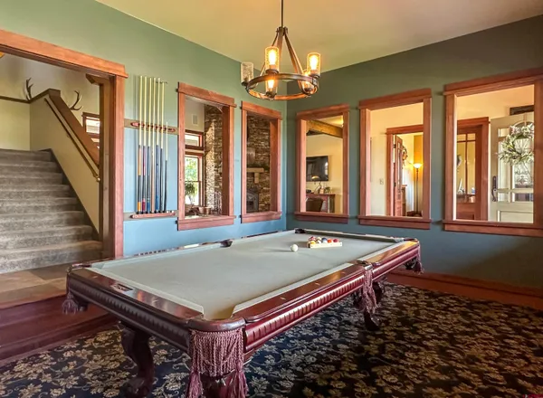 a room with pool table and windows