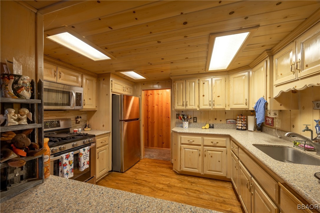 39388 Lodge Road Fawnskin, CA 92333 - Photo 25 of 45 a kitchen with stainless steel appliances granite countertop a sink stove and refrigerator