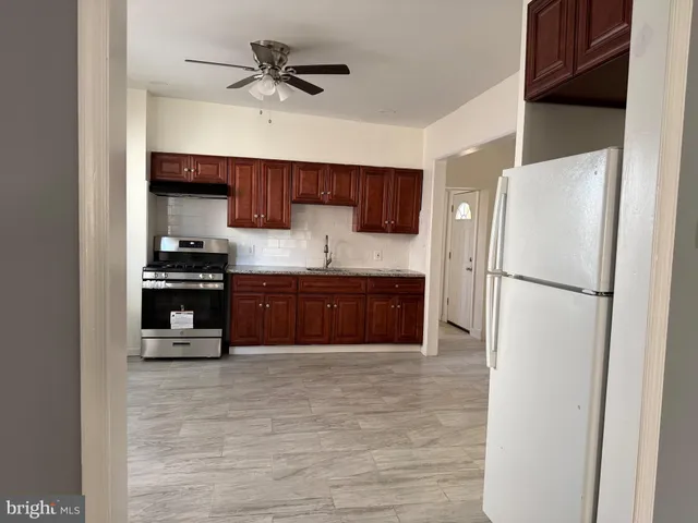 a kitchen with stainless steel appliances granite countertop a stove a sink and a refrigerator