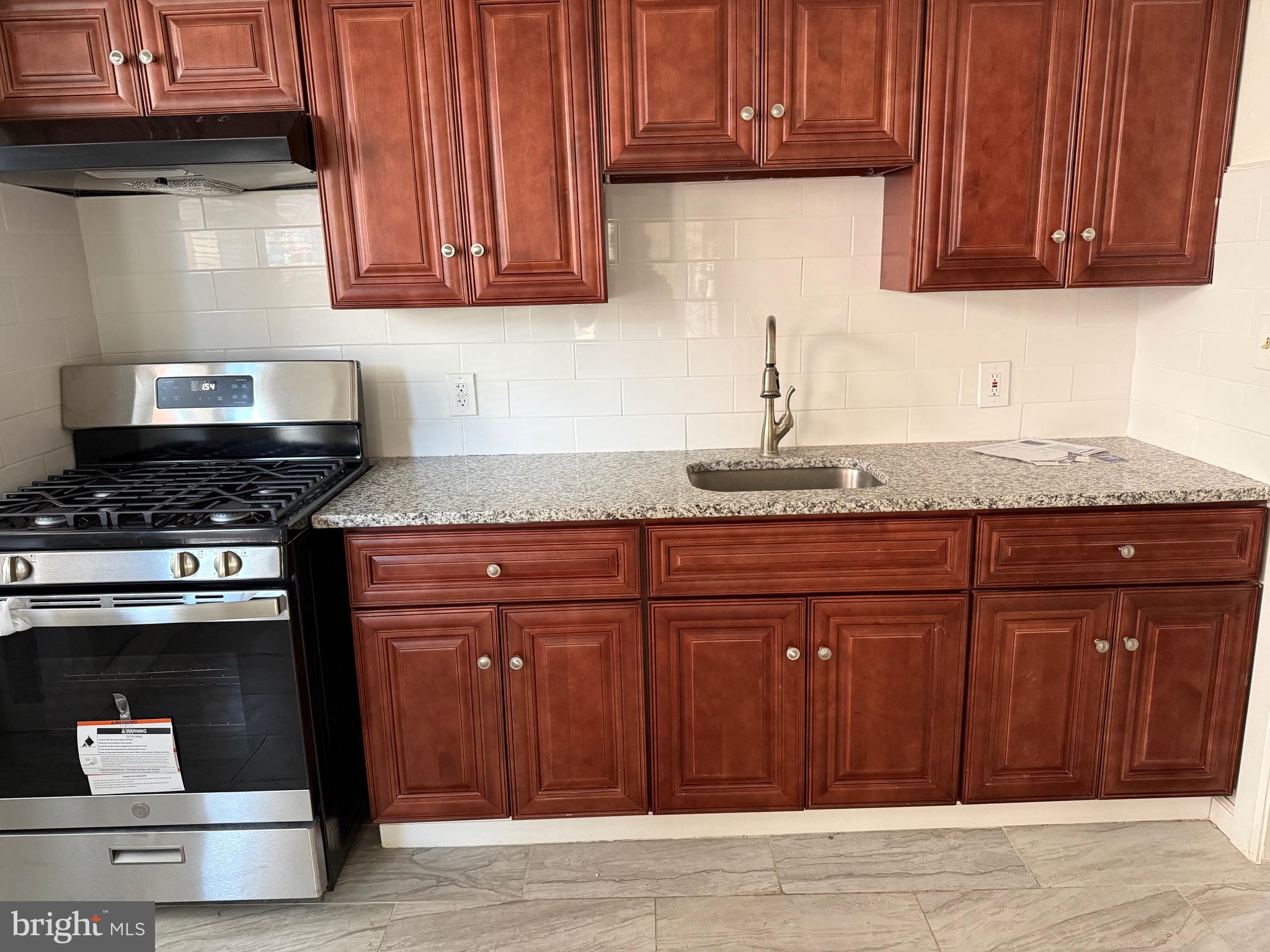 216 South 7th Street Darby, PA 19023 - Photo 22 of 46 a kitchen with granite countertop cabinets and stainless steel appliances