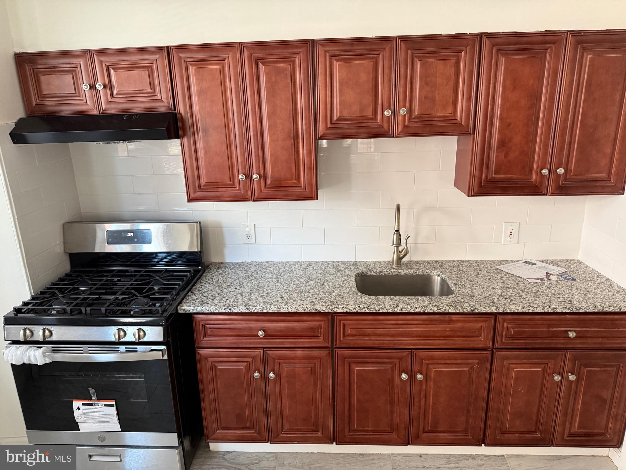 216 South 7th Street Darby, PA 19023 - Photo 27 of 46 a kitchen with granite countertop stainless steel appliances a stove a sink and dishwasher