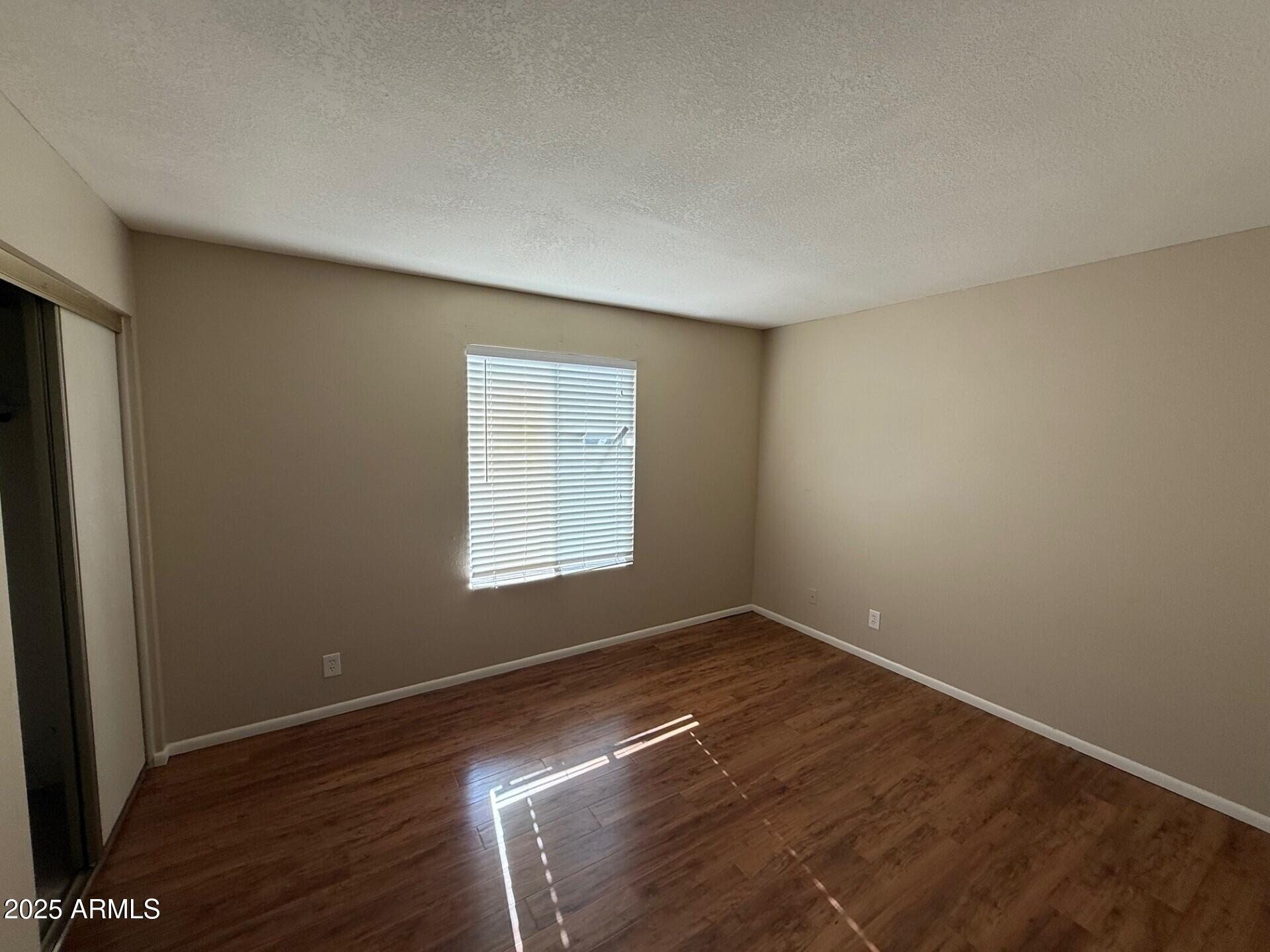 14806 Yerba Buena Way, Unit A Fountain Hills, AZ 85268 - Photo 11 of 16 a view of an empty room with wooden floor and a window