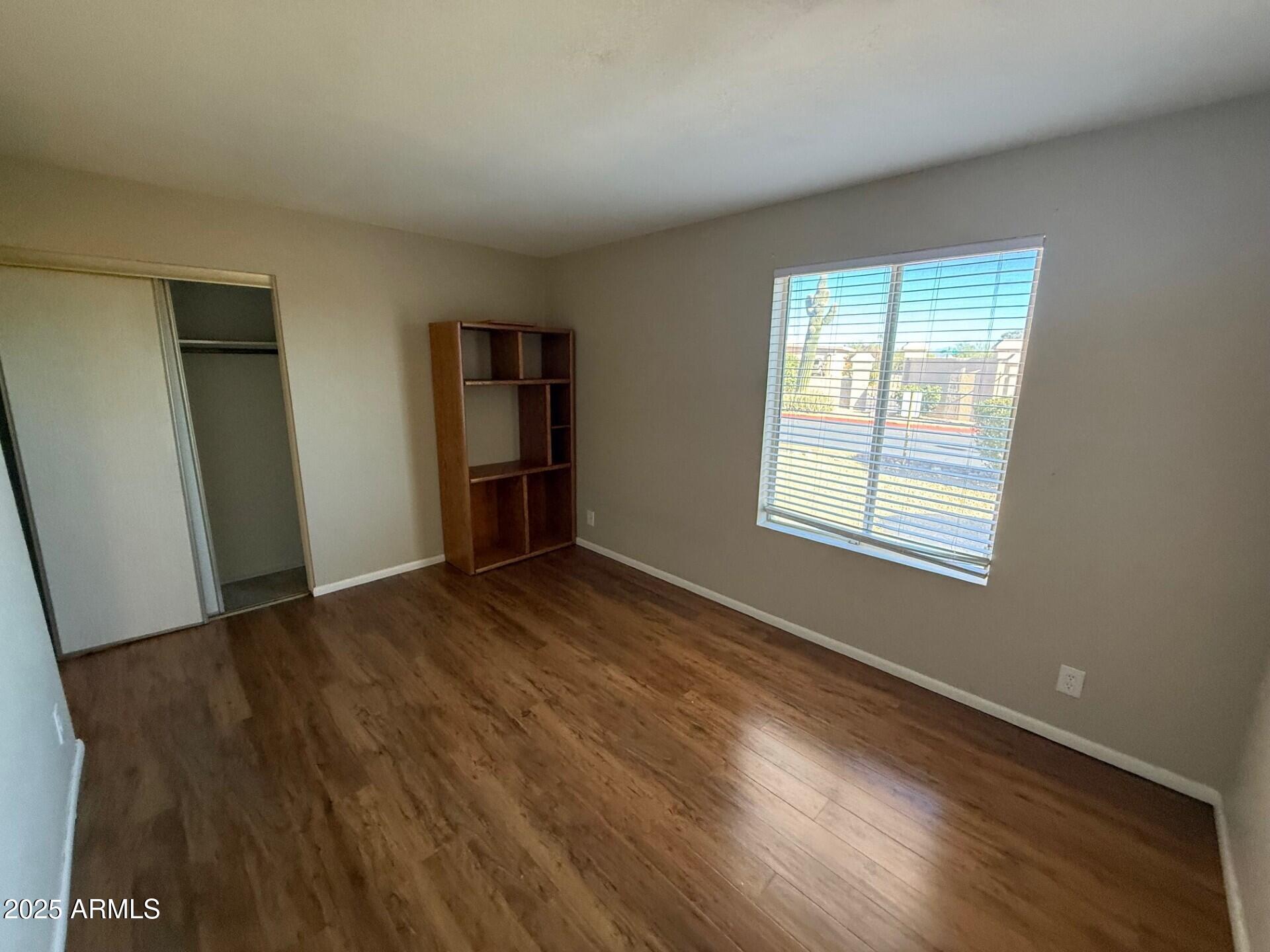 14806 Yerba Buena Way, Unit A Fountain Hills, AZ 85268 - Photo 13 of 16 a view of an empty room with wooden floor and a window