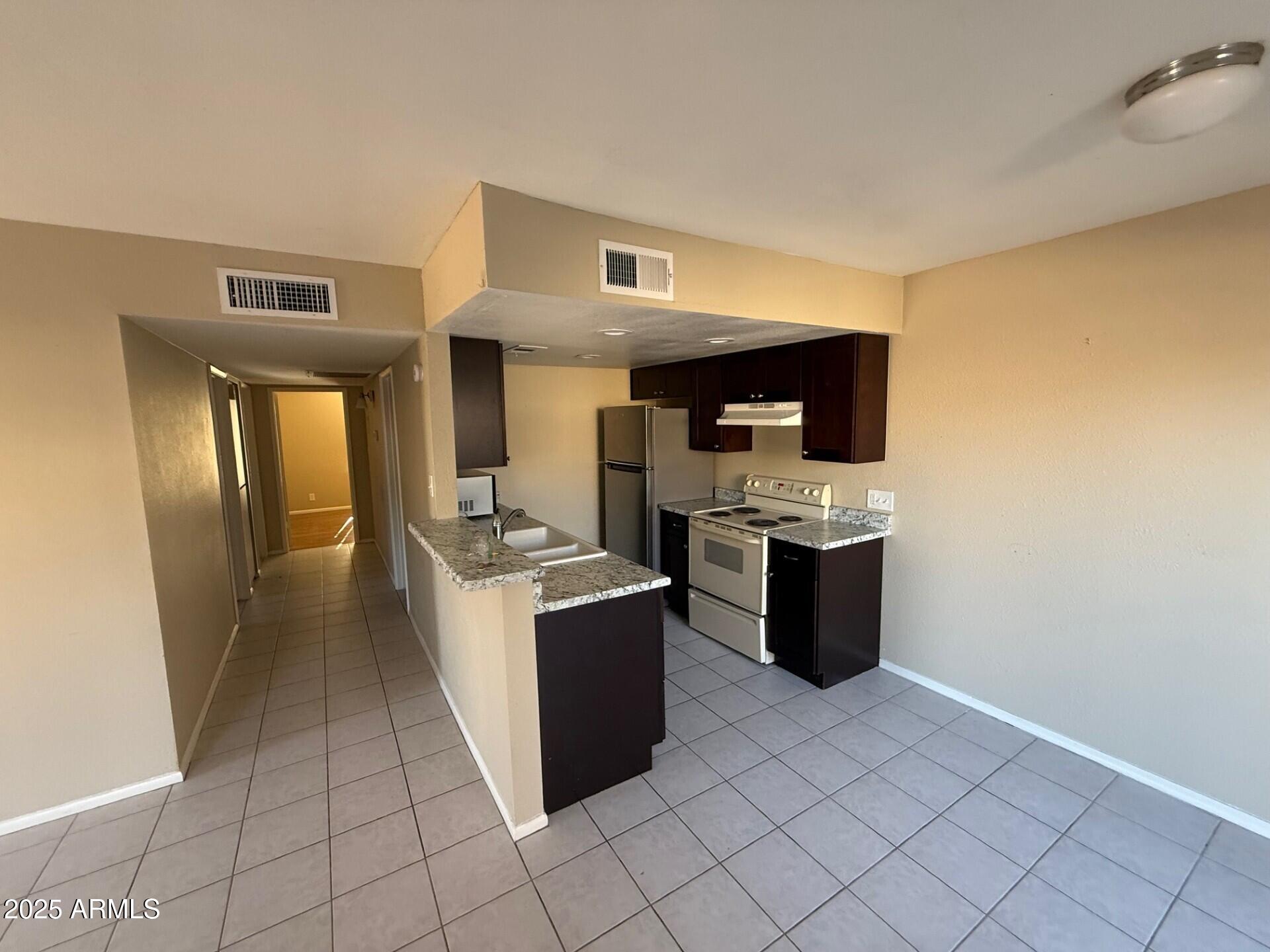 14806 Yerba Buena Way, Unit A Fountain Hills, AZ 85268 - Photo 10 of 16 a kitchen with stainless steel appliances granite countertop a stove a sink and a refrigerator