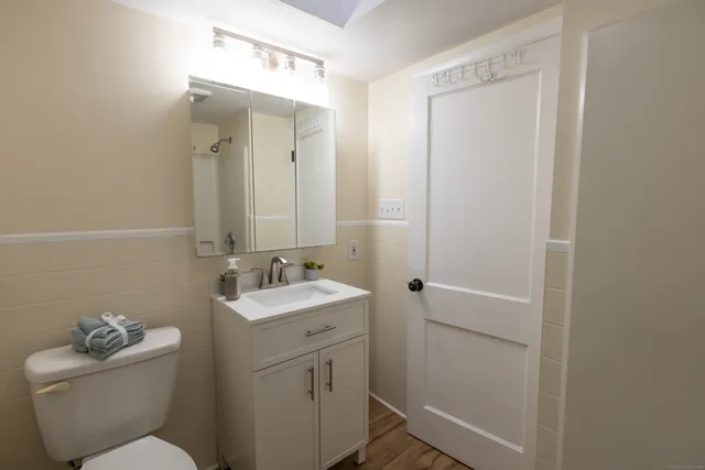 a bathroom with a toilet sink and mirror