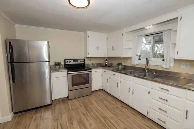 a kitchen with granite countertop white cabinets and white appliances