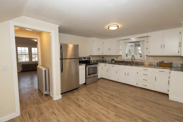a kitchen with a refrigerator sink and white cabinets