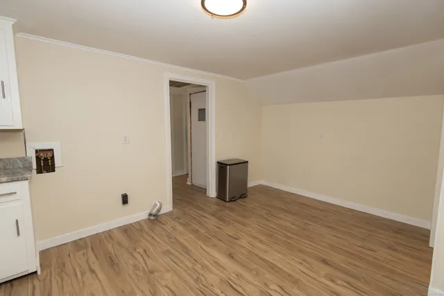 a view of an empty room with wooden floor