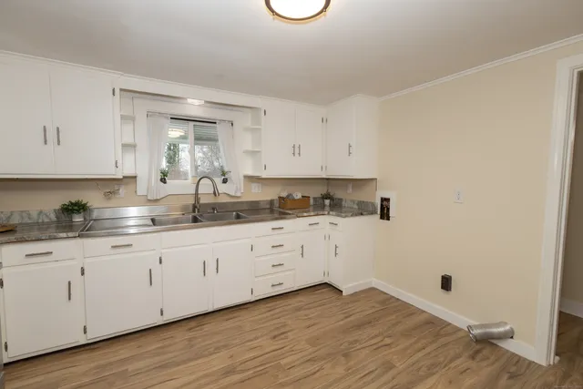a kitchen with granite countertop white cabinets and white appliances