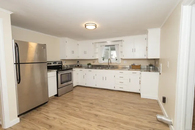 a kitchen with white cabinets and white appliances