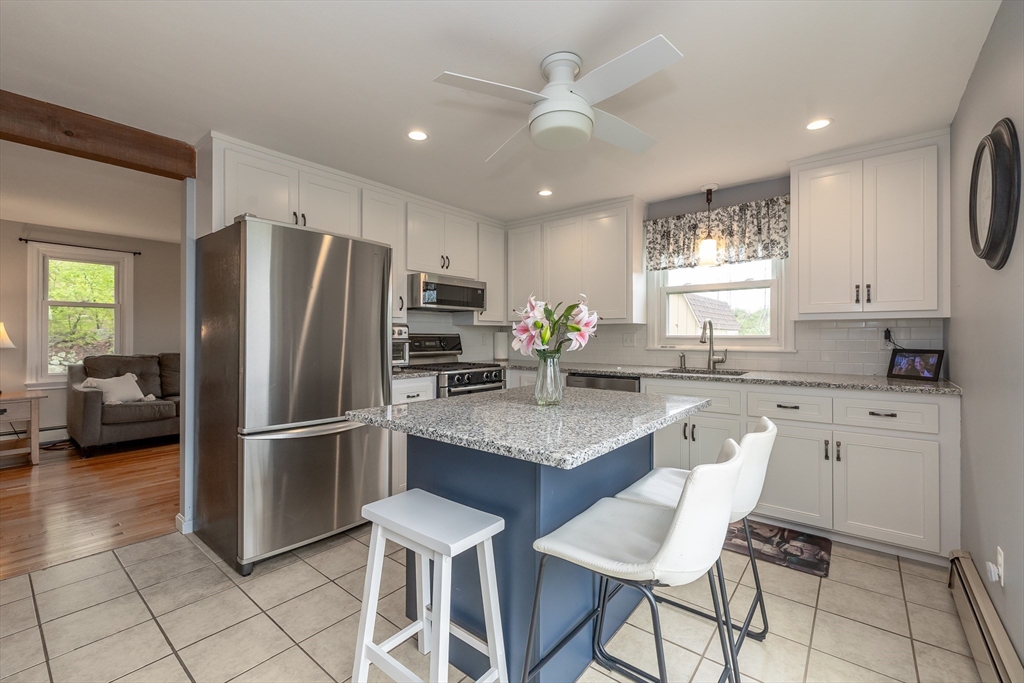 7 Adirondack Road Chelmsford, MA 01824 - Photo 3 of 31 a kitchen with stainless steel appliances granite countertop a refrigerator a sink a stove a dining table and chairs