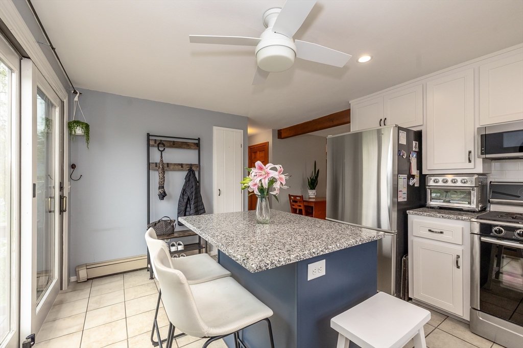 7 Adirondack Road Chelmsford, MA 01824 - Photo 4 of 31 a kitchen with refrigerator cabinets dining table and chairs
