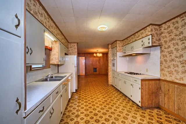a kitchen with granite countertop a sink stove and cabinets
