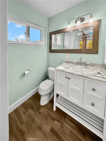 a bathroom with a granite countertop toilet sink and mirror