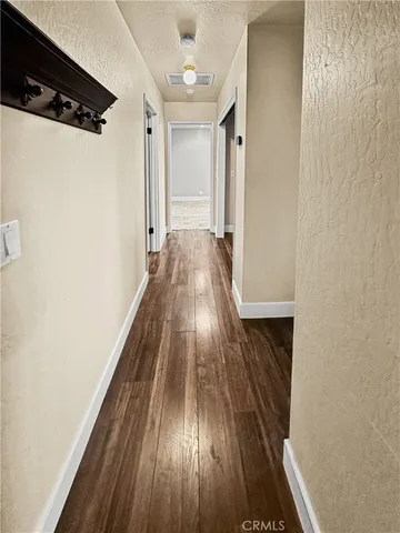 a view of a hallway with wooden floor