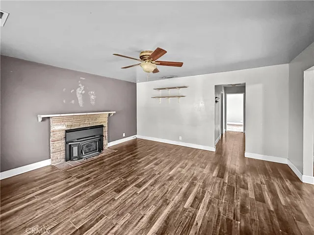 a view of empty room with wooden floor and fireplace