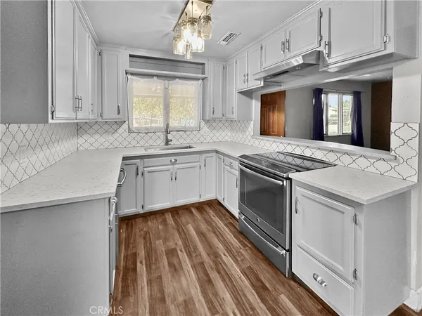 a kitchen with granite countertop a sink stainless steel appliances and cabinets