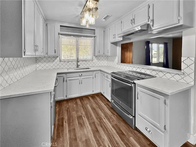 a kitchen with granite countertop a sink stainless steel appliances and cabinets