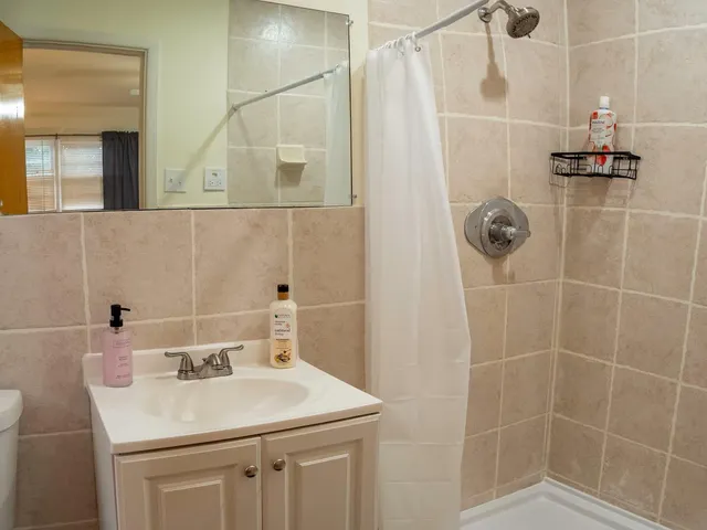 a bathroom with a sink shower and a mirror