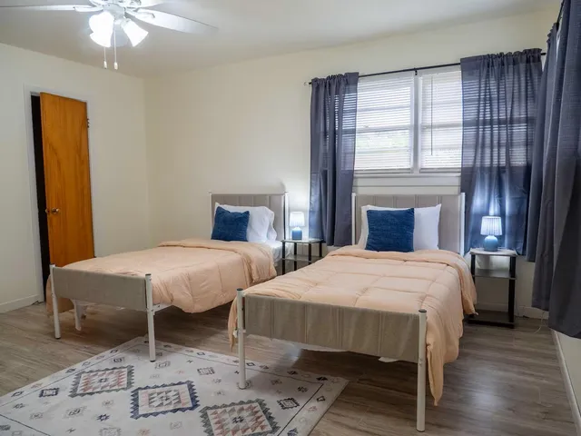 a bedroom with two beds and a window