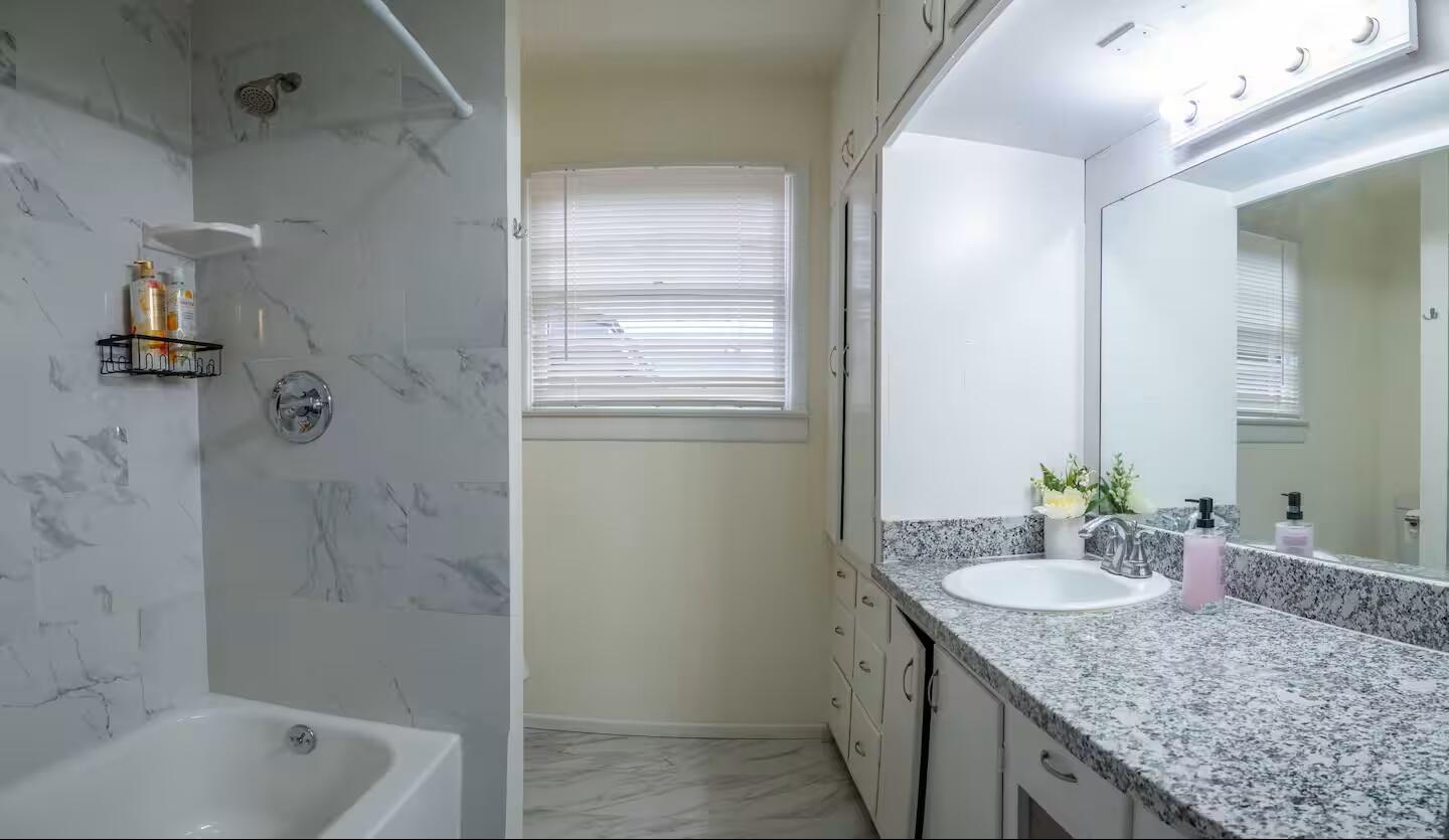 3506 46th Street Lubbock, TX 79413 - Photo 22 of 27 a bathroom with a granite countertop sink and a mirror