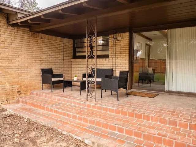 a view of a patio with table and chairs and potted plants