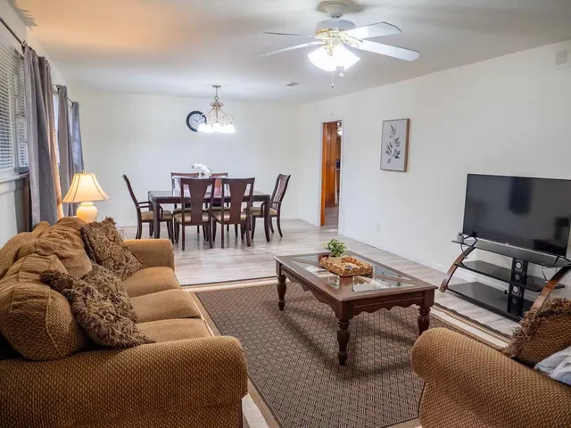 a living room with furniture a flat screen tv and a window