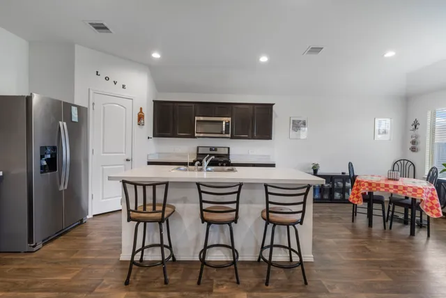 a kitchen with stainless steel appliances a stove refrigerator sink microwave and cabinets