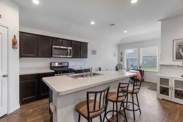 a kitchen with stainless steel appliances granite countertop a sink stove and refrigerator