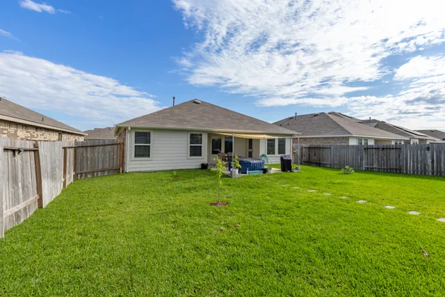 a view of a backyard with table and chairs and a barbeque
