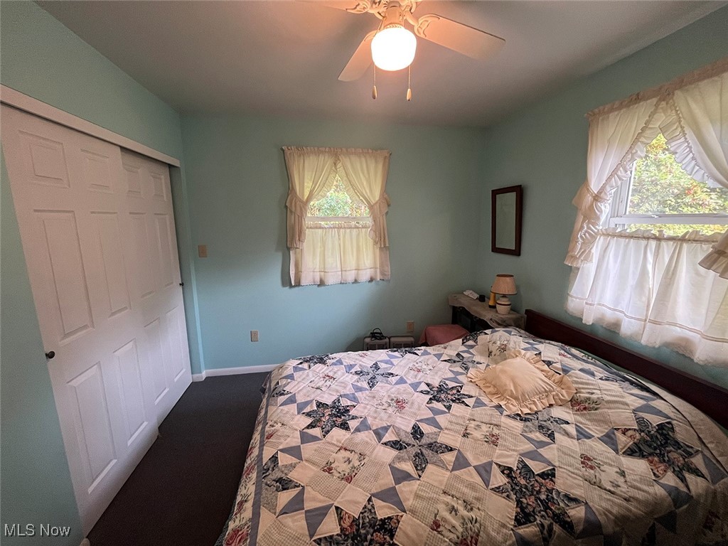 68477 Geese Road Cambridge, OH 43725 - Photo 21 of 32 Bedroom featuring a closet, a ceiling fan, and dark colored carpet