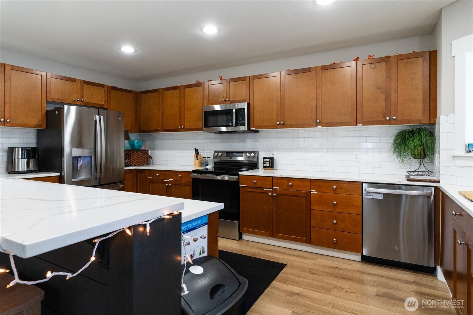 15150 140th Way Southeast, Unit T104 Renton, WA 98058 - Photo 36 of 40 a kitchen with stainless steel appliances a sink dishwasher a refrigerator a stove a microwave oven with cabinets and wooden floor