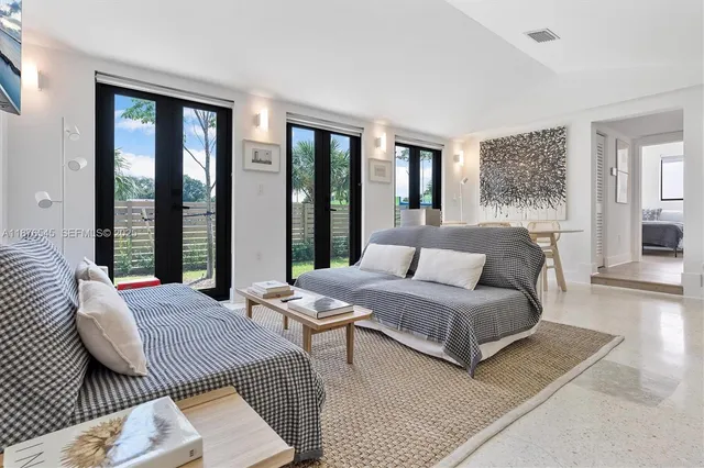 a room with a table chairs and a living room