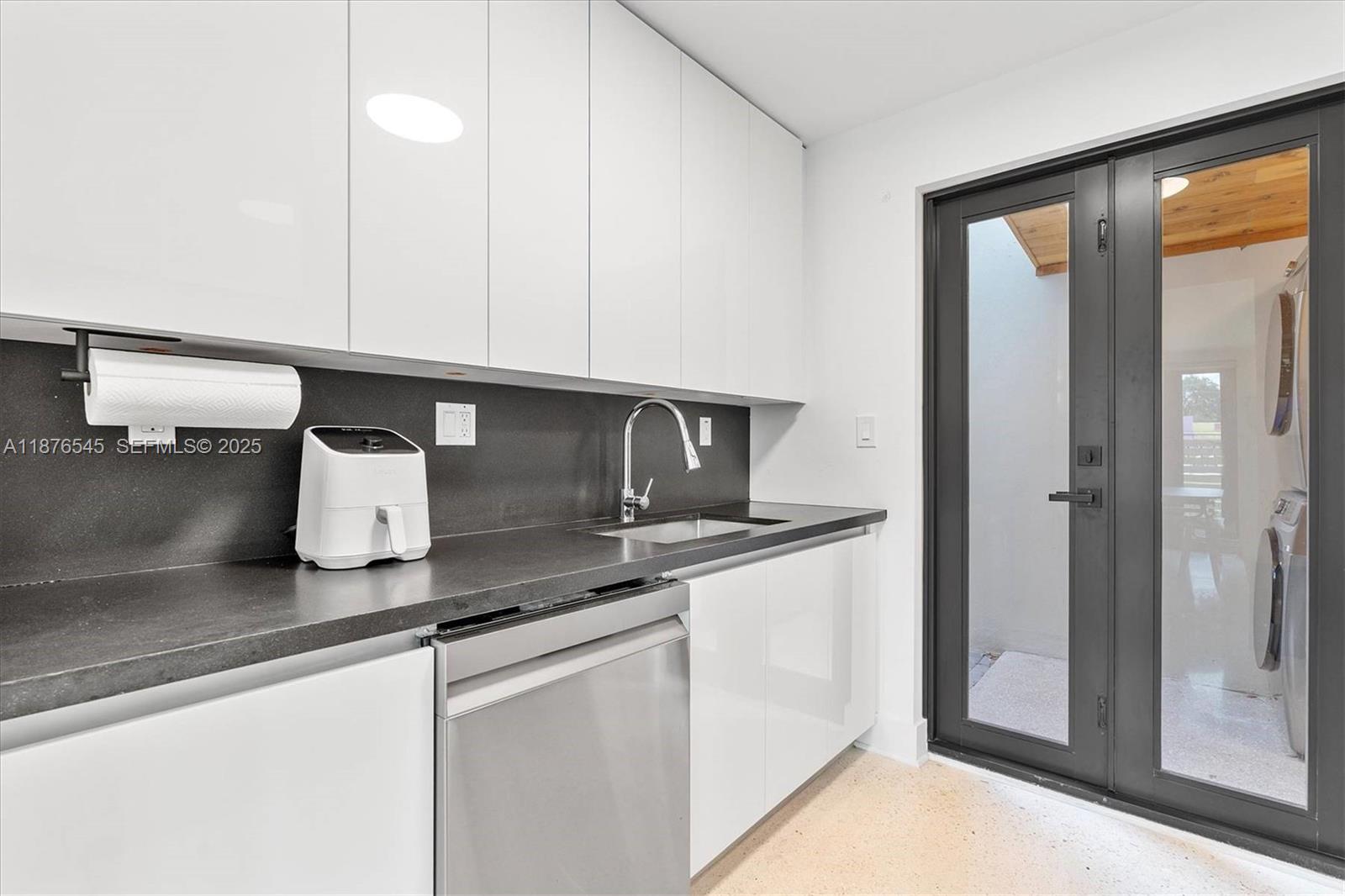 1076 Northwest 55th Street Miami, FL 33127 - Photo 25 of 96 a kitchen with stainless steel appliances granite countertop a sink and a refrigerator