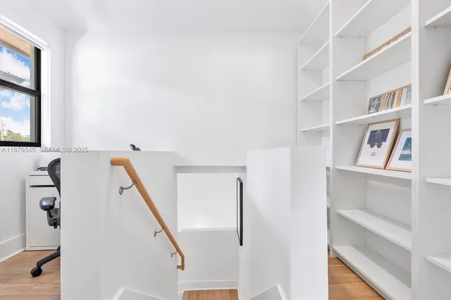 a bedroom with a bed wooden floor and window