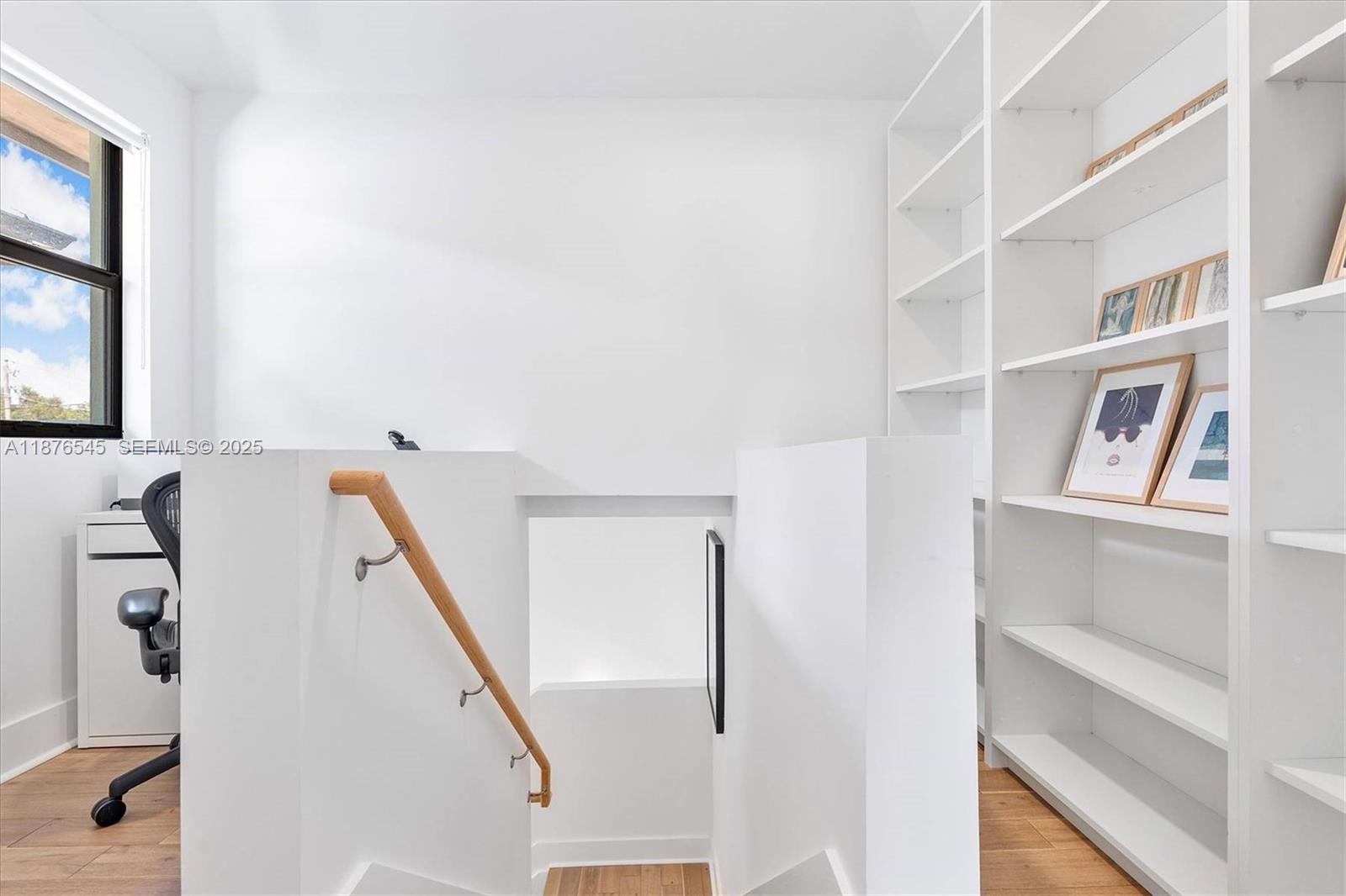 1076 Northwest 55th Street Miami, FL 33127 - Photo 45 of 96 a view of staircase with lots of frames on wall and a window
