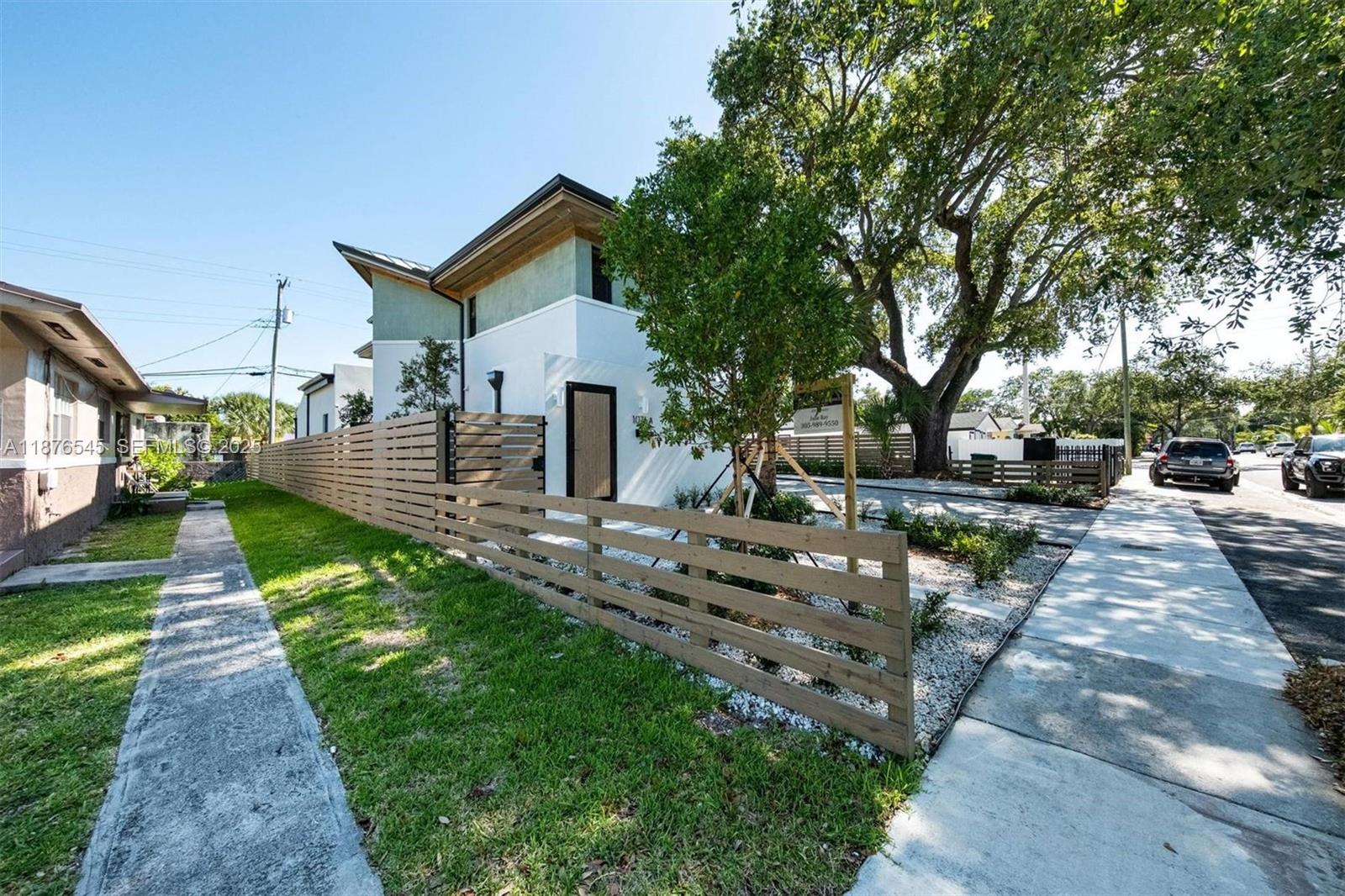 1076 Northwest 55th Street Miami, FL 33127 - Photo 61 of 96 a front view of a house with a yard