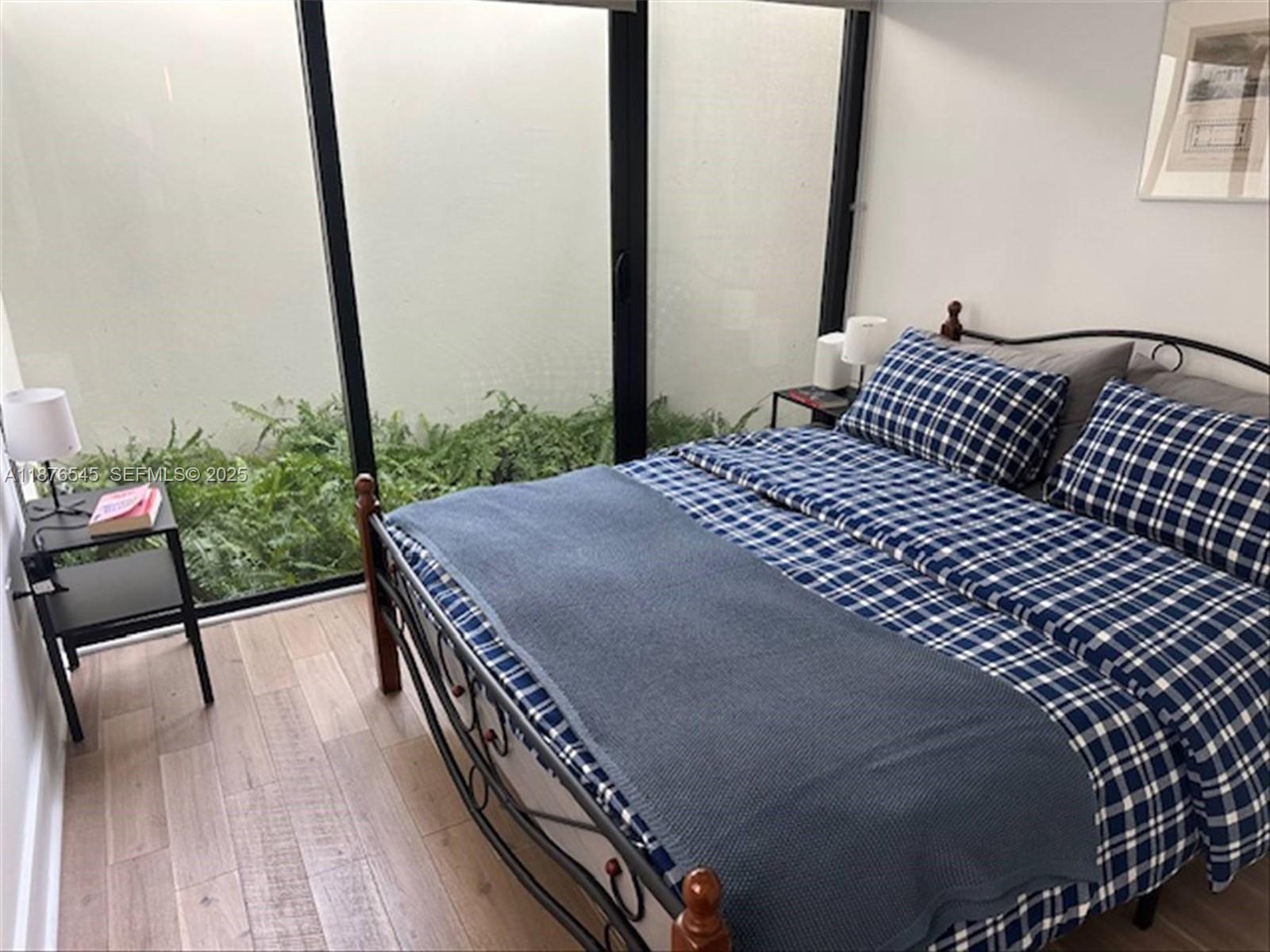 1076 Northwest 55th Street Miami, FL 33127 - Photo 82 of 96 a bedroom with a bed wooden floor and window