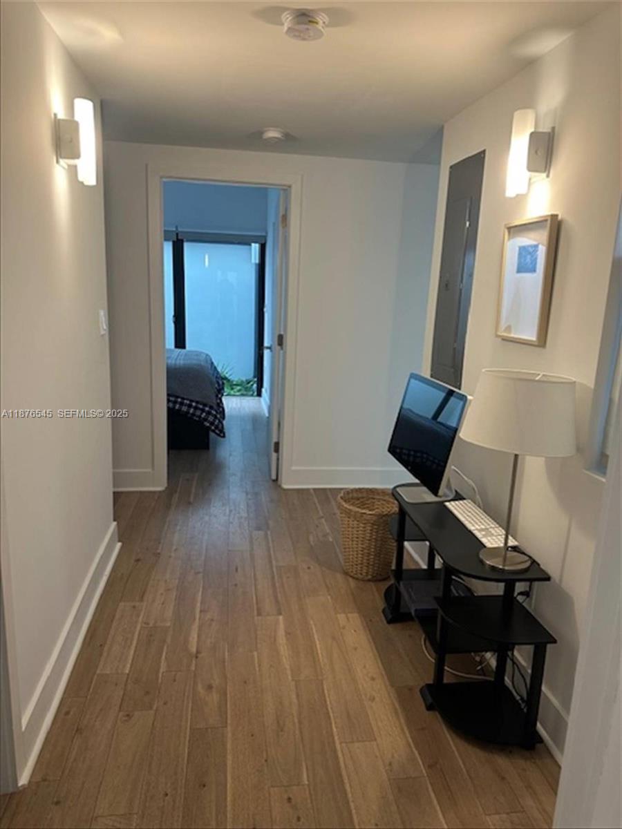 1076 Northwest 55th Street Miami, FL 33127 - Photo 83 of 96 a view of a workspace with wooden floor and a bathroom