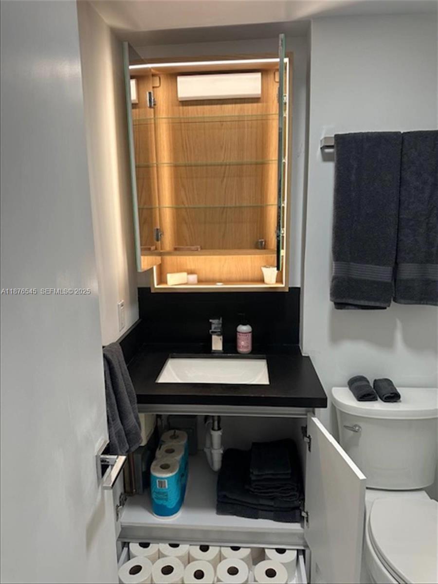 1076 Northwest 55th Street Miami, FL 33127 - Photo 84 of 96 a bathroom with a sink a toilet and a window