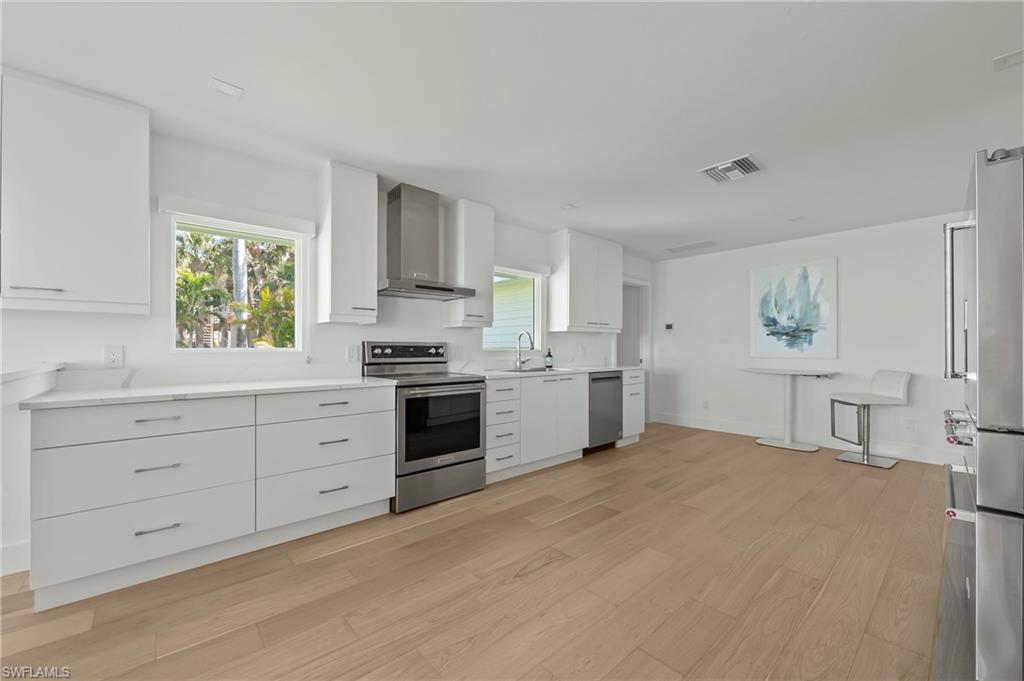 71 18th Avenue South Naples, FL 34102 - Photo 21 of 50 a kitchen with granite countertop white cabinets and white appliances