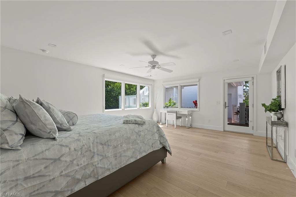 71 18th Avenue South Naples, FL 34102 - Photo 23 of 50 a bedroom with a large bed and a chandelier