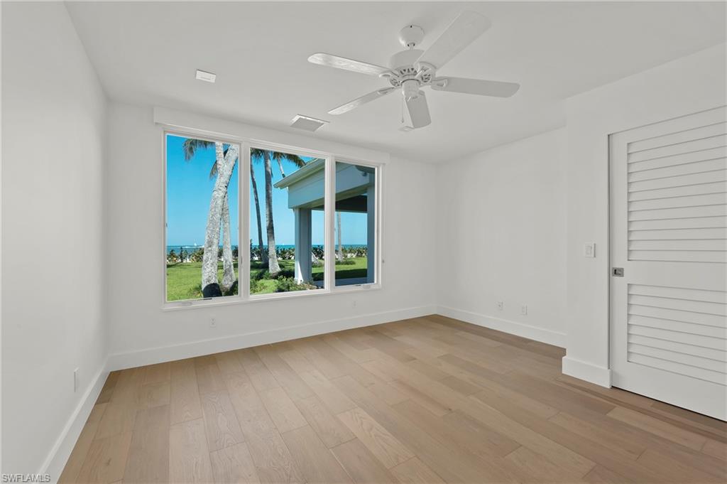 71 18th Avenue South Naples, FL 34102 - Photo 33 of 50 an empty room with wooden floor fan and windows